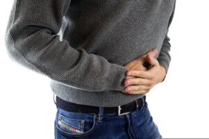 Mann hält sich mit beiden Händen den Bauch
