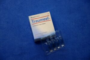 Traumeel Medikamentenverpackung und einige Ampullen im Vordergrund